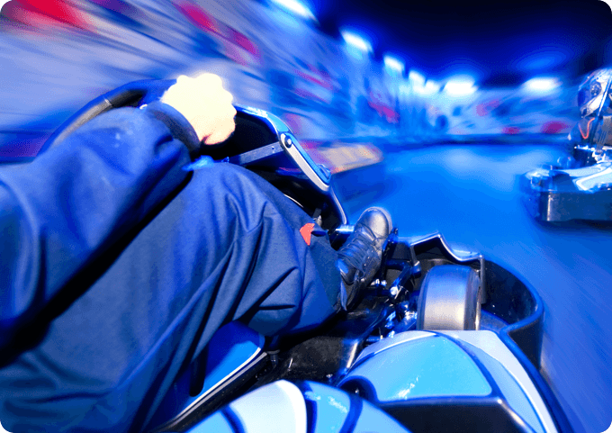A person driving a go - kart at night.