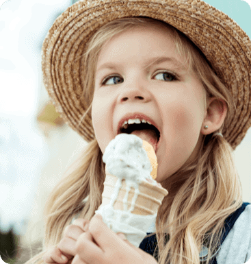 A little girl eating an ice cream cone.