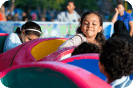A group of children riding a ride at an amusement park.