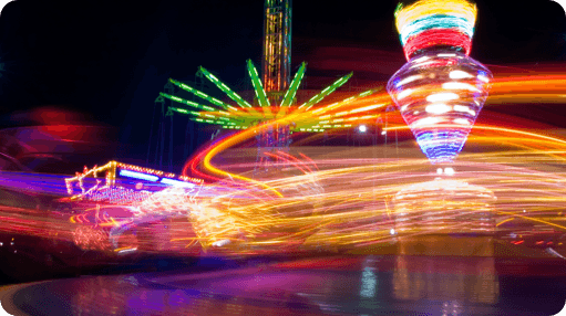 A blurry image of a carnival ride at night.