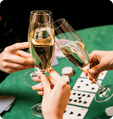 Two people toasting champagne glasses at a poker table.