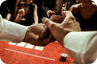A man is holding a poker card in front of a group of people.