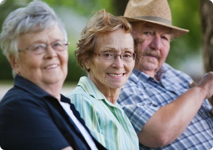 A group of older people sitting in a park.