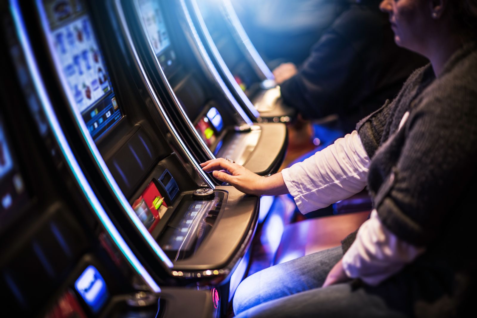 A woman is playing a slot machine in a casino.