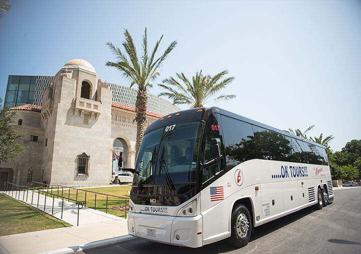 A white bus parked in front of a building.
