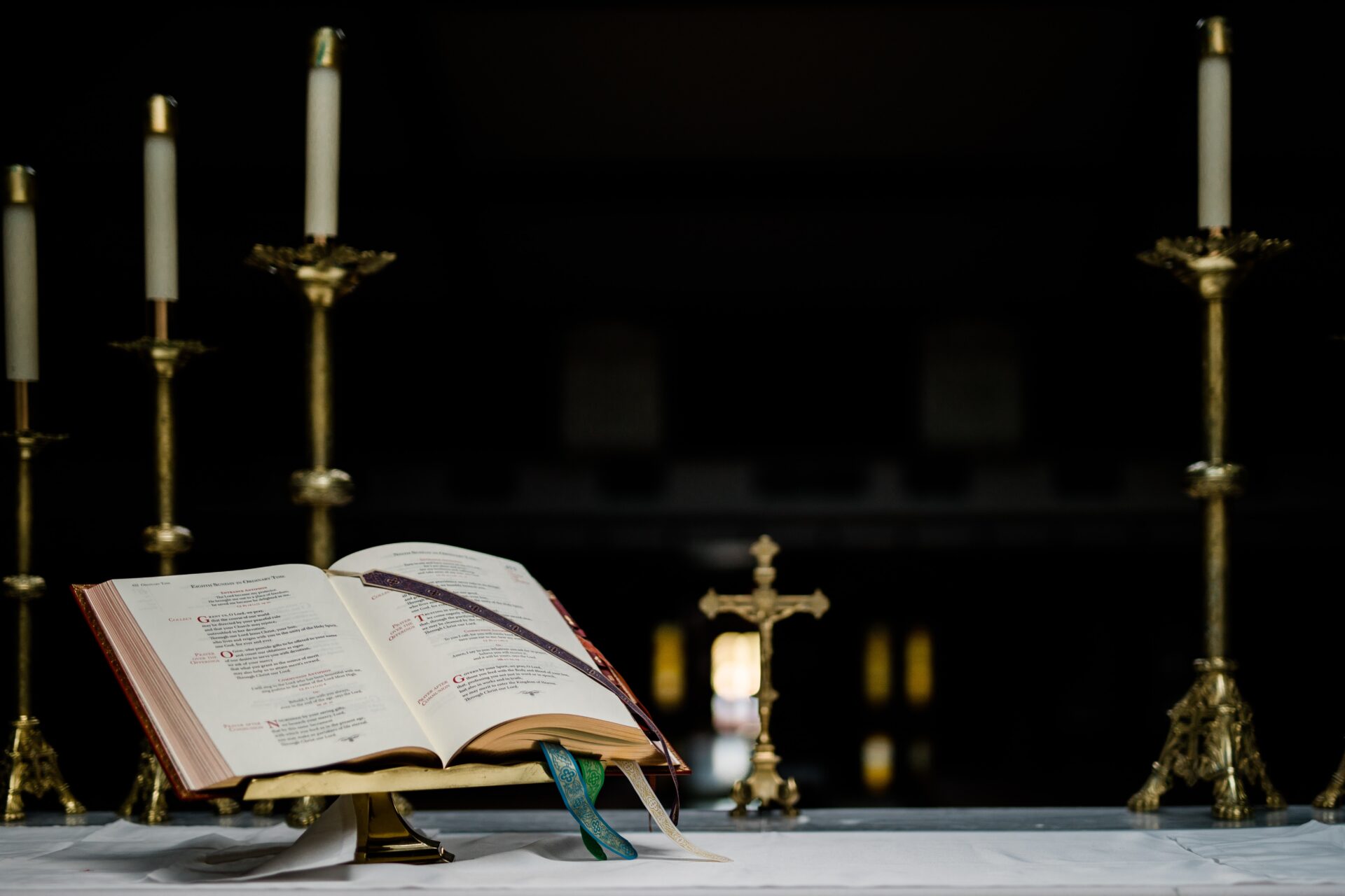 An open book and candles on a table.