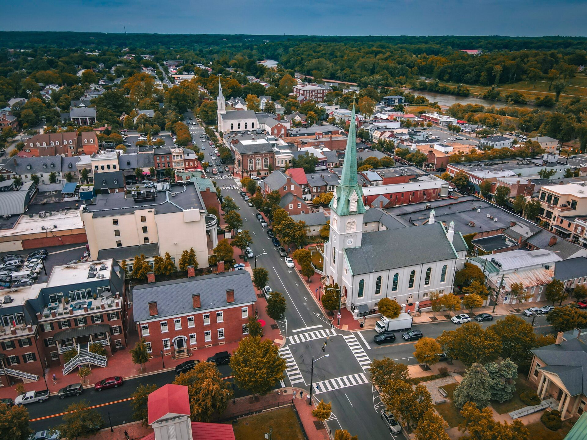 An aerial view of a town with a church in the background.