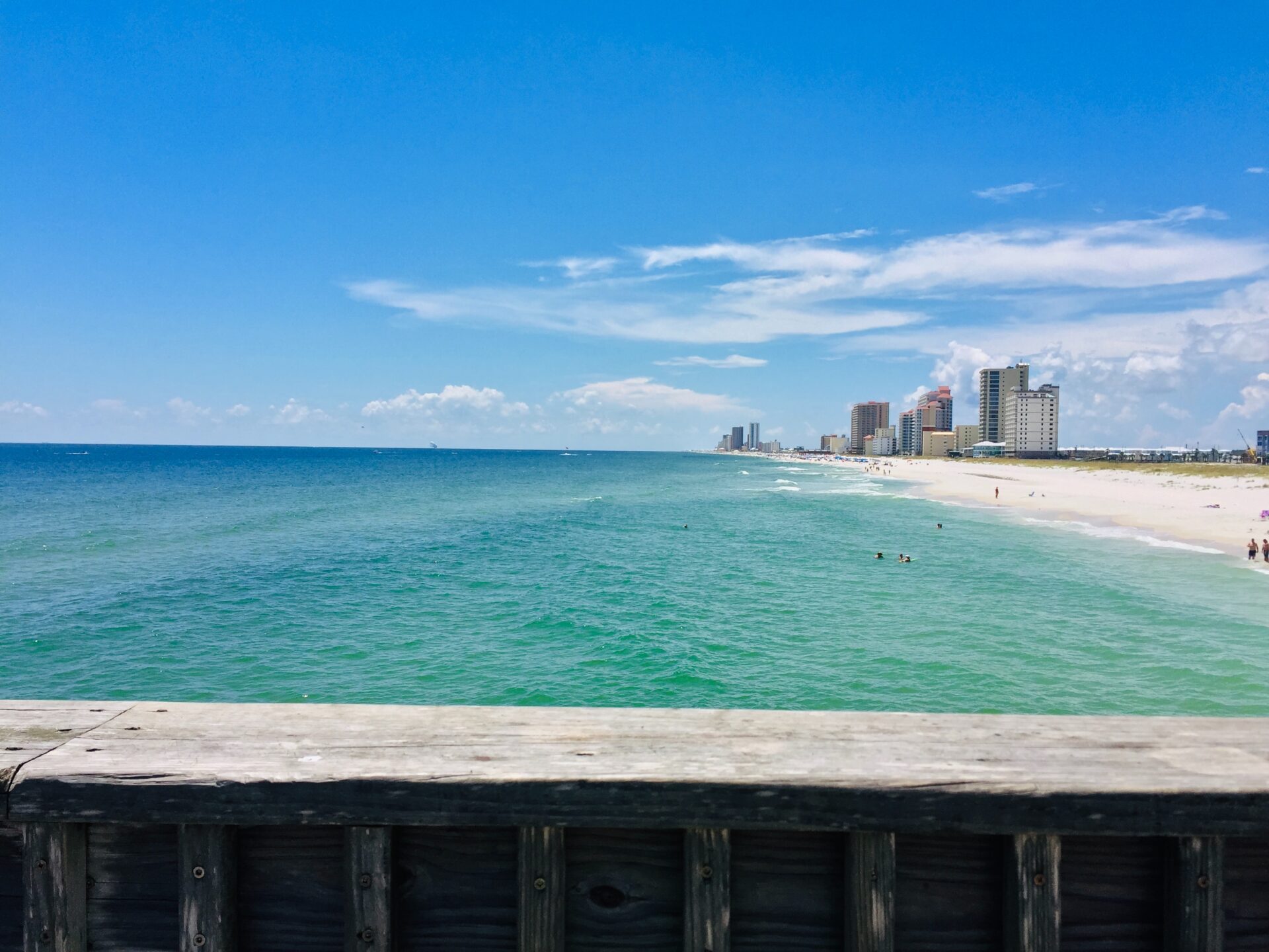 A view of the beach from a wooden boardwalk.
