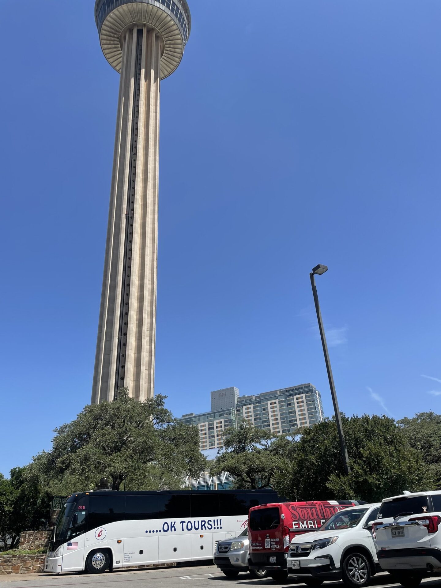 A group of cars parked in front of a tower.