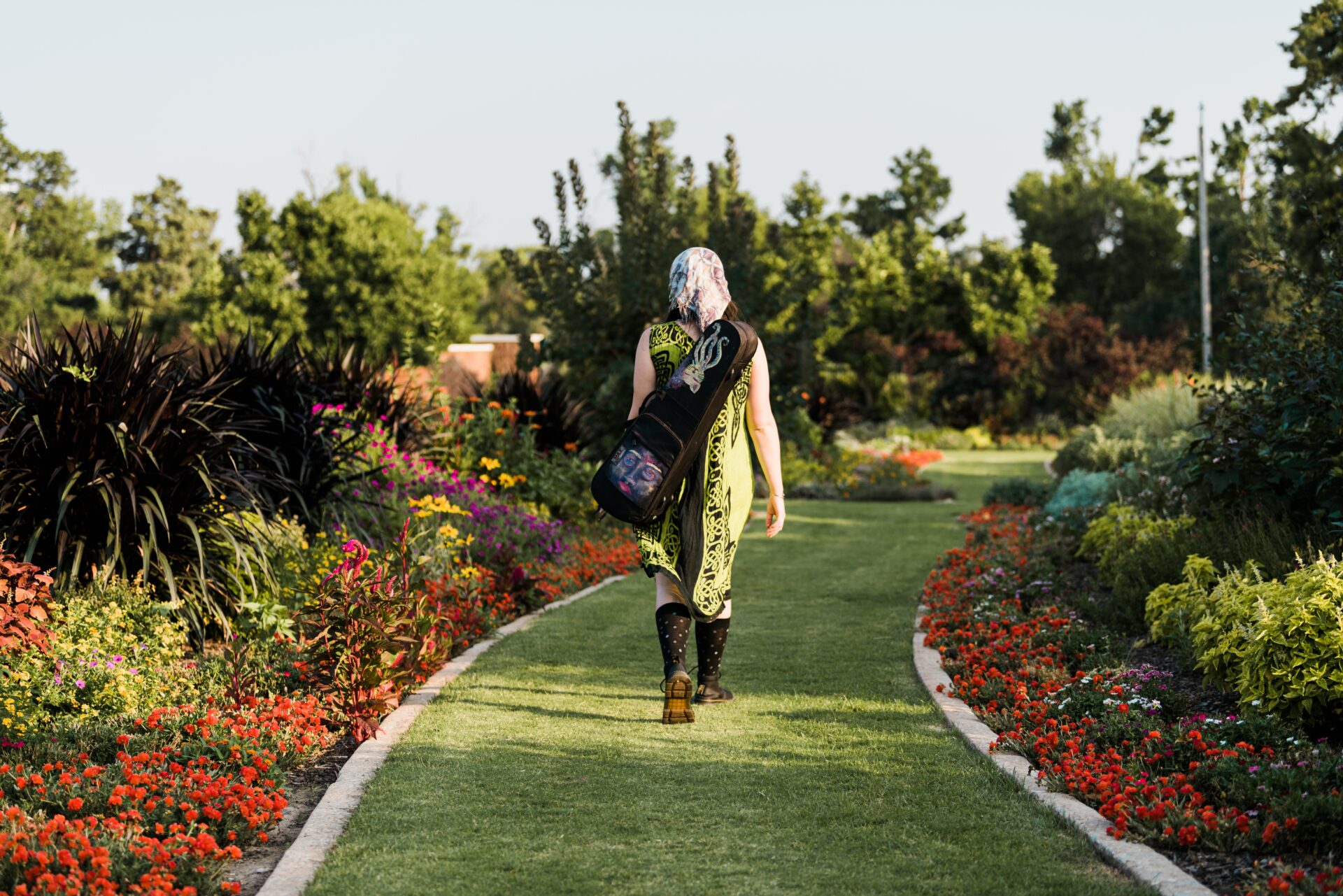 A woman walking down a path in a garden.